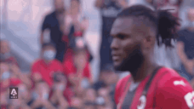 a man in a red jersey with the number 3 on it stands in front of a crowd