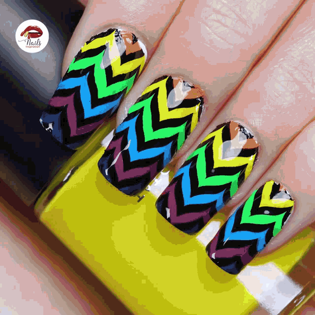 a close up of a woman 's nails with a yellow bottle of nail polish in the foreground