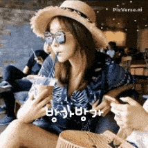 a woman wearing a hat and sunglasses is drinking from a cup with a straw