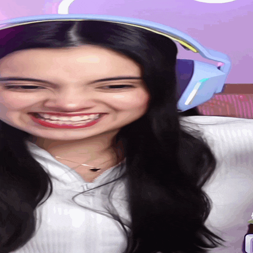 a woman wearing headphones and a white shirt is smiling