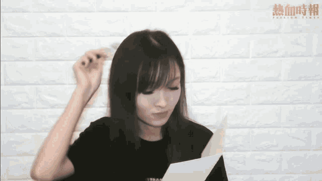 a woman is holding a piece of paper in front of a white brick wall that says fashion time
