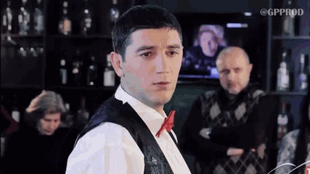 a man in a bow tie is standing in front of a gp prod logo