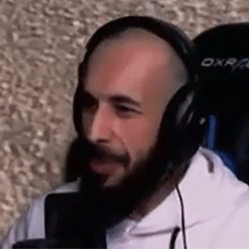a bald man with a beard is wearing headphones and a microphone .
