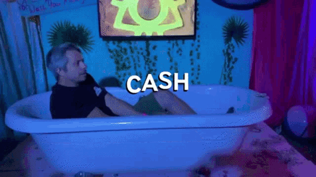 a man is laying in a bathtub with the word cash on the bottom
