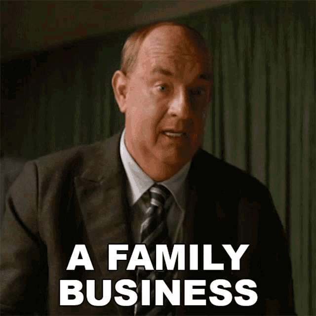 a man in a suit and tie says " a family business " in white letters