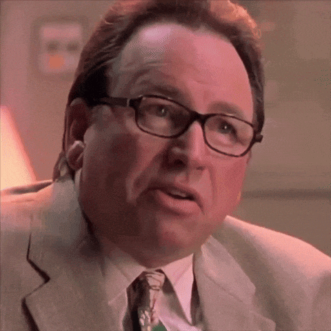 a close up of a man wearing glasses and a suit and tie