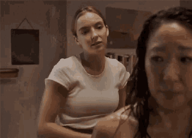 a couple of women are standing next to each other in a room .