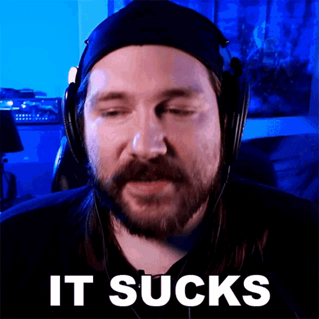 a man wearing headphones says " it sucks " in white letters