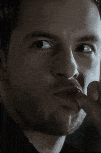 a close up of a man 's face with a black background