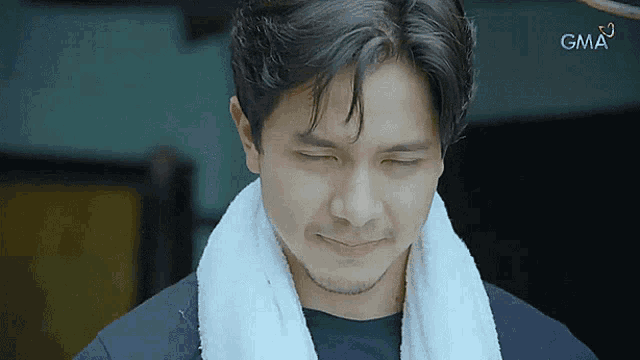 a man with a towel around his neck and a gma logo in the background