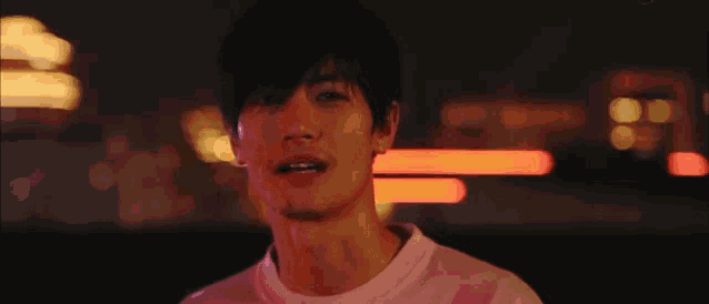 a close up of a man 's face in front of a blurry background of lights .