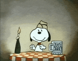 snoopy sits at a table with a root beer mug