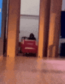 a blurry picture of a person sitting in a chair in a room with a red chair .