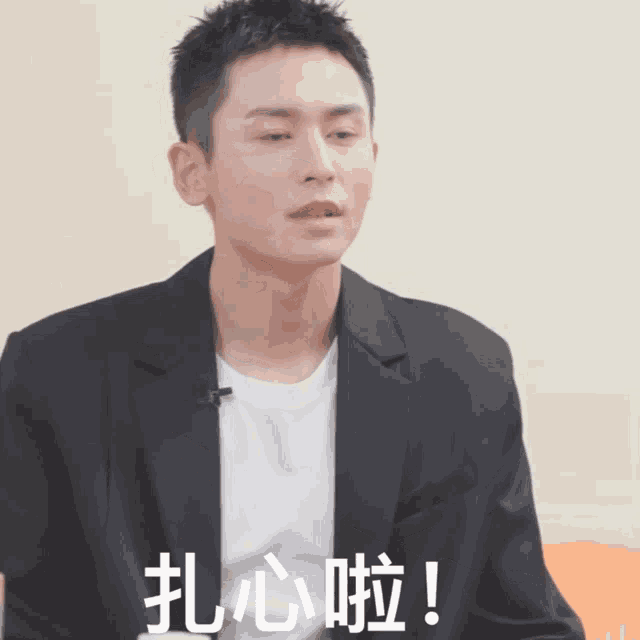 a man wearing a black jacket and a white t-shirt has chinese characters on his face