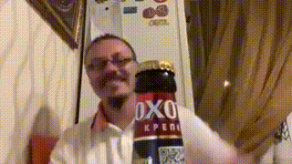 a man is holding a bottle of oxo
