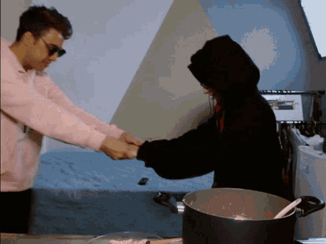 two people holding hands in front of a pot