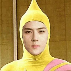 a man is wearing a yellow costume with a pink stripe and a yellow hat .