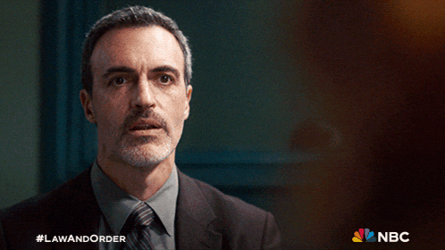 a man in a suit and tie has the hashtag lawandorder on his face