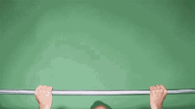 a man with a beard is doing pull ups on a bar .