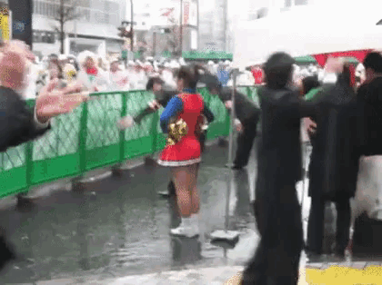a cheerleader in a red and blue outfit is dancing in the rain .