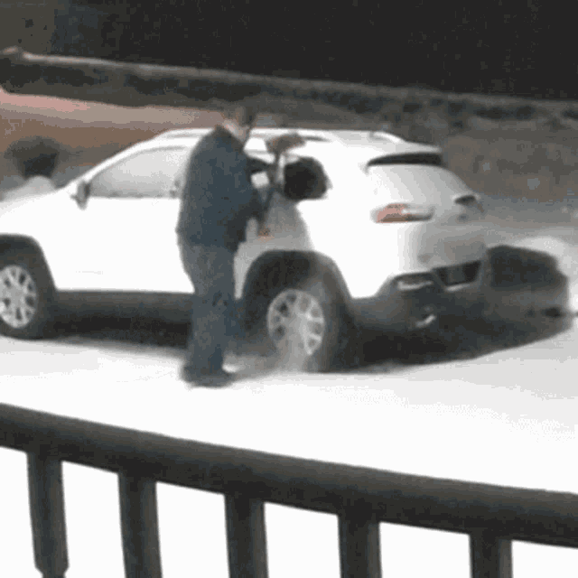 a man standing in front of a white suv