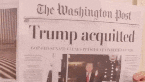 a man is holding a washington post newspaper in front of his face .