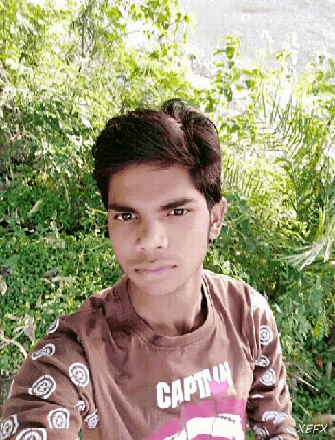 a young man taking a selfie with a captain shirt on