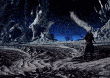 a person is standing in a cave with a sword in their hand .