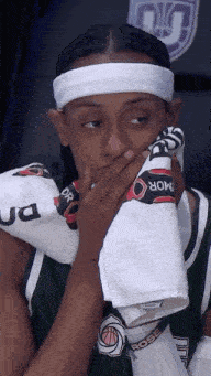 a basketball player wipes his face with a towel that says armor on it