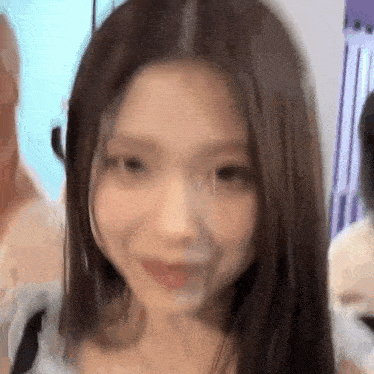 a close up of a woman 's face with long hair and a smile on her face .
