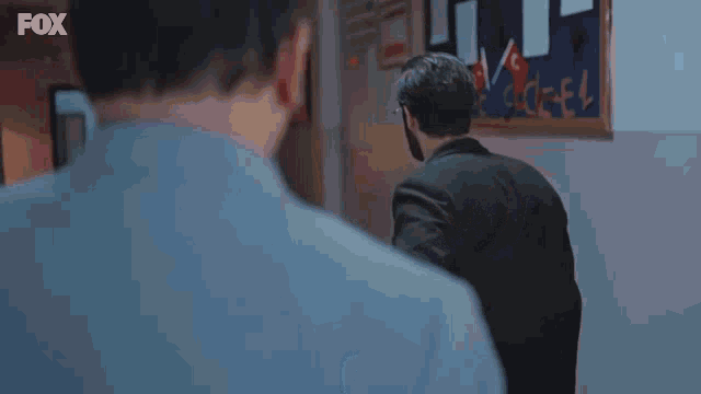 a man with glasses is pointing a gun at the camera with the fox logo in the corner