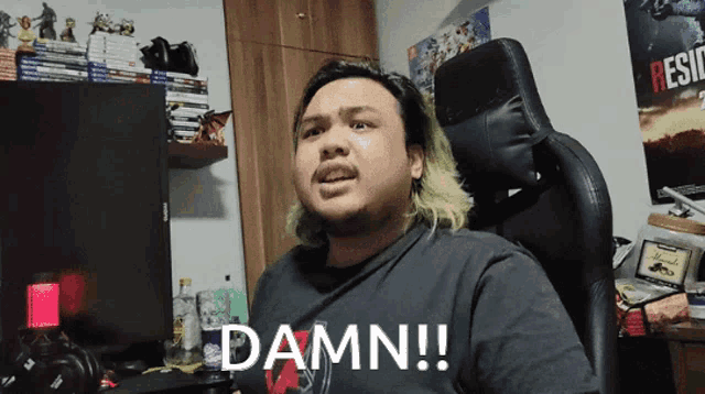 a man sitting in a chair says damn