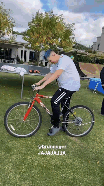 a man is riding a bicycle on a grassy field .