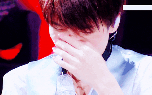 a young man covering his mouth with his hand
