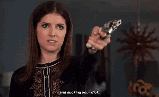 a woman is pointing a gun with the words and sucking your dick behind her