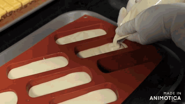 a person is pouring liquid into a silicone mold that says made in animotica on the bottom