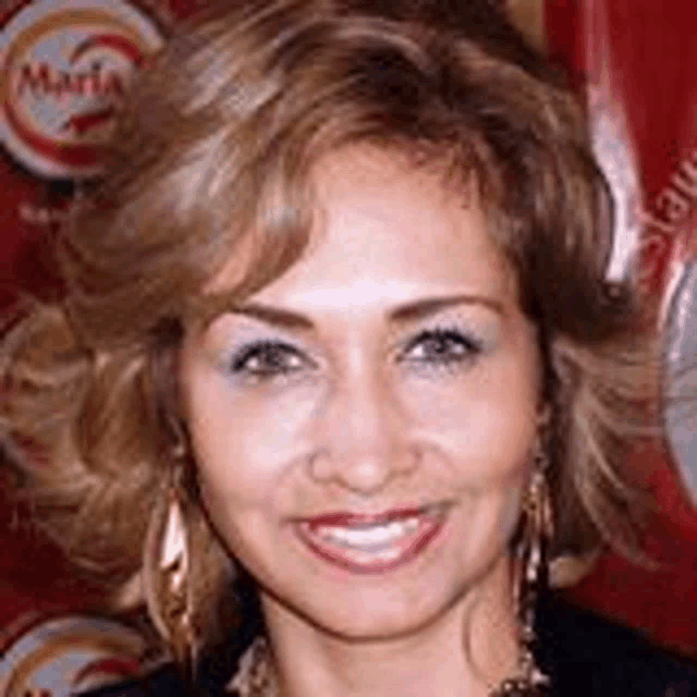 a close up of a woman 's face smiling in front of a red background .