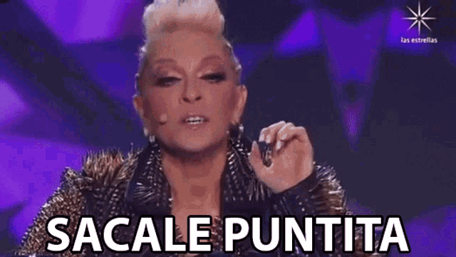 a woman in a spiked jacket is making a funny face and says sacale puntita
