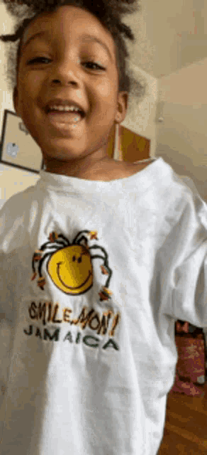 a young girl wearing a white shirt with a smiley face on it