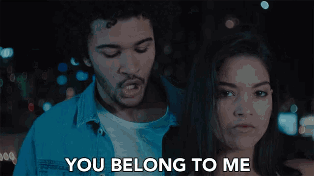 a man and a woman are standing next to each other with the words you belong to me above them