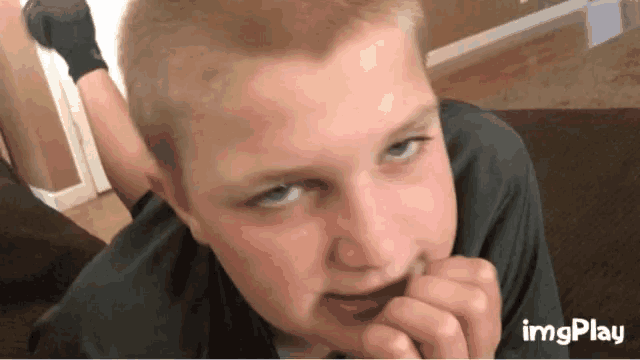 a close up of a boy 's face with imgplay written on the bottom right