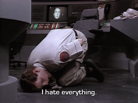 a man is kneeling on the floor with the words i hate everything behind him