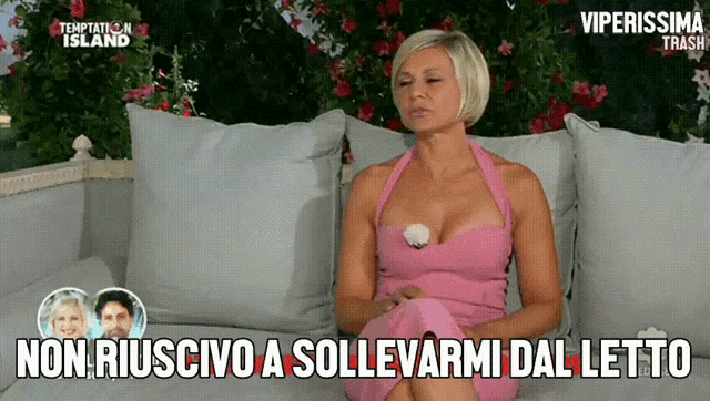 a woman in a pink dress sits on a couch with the words non riuscivo a sollevarmi dal letto below her