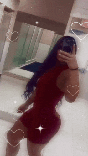 a woman in a red dress is taking a selfie in a bathroom mirror