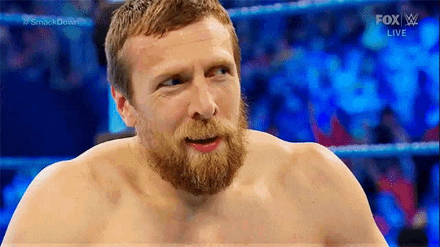 a shirtless wrestler with a beard is on a fox live broadcast .