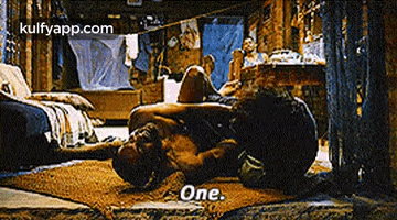 a man is laying on the floor in a room with the words `` one '' written on the bottom .