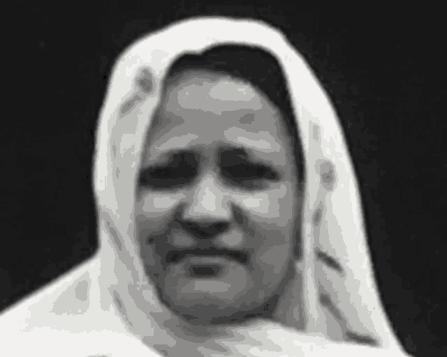 a black and white photo of a woman wearing a hijab .