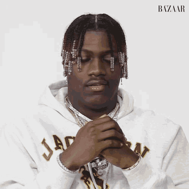 a man wearing a white hoodie with the word bazaar on the front