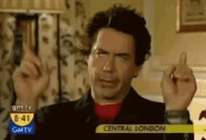 a man is giving the middle finger in front of a gmtv advertisement