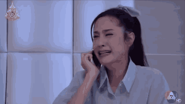 a woman crying while talking on a cell phone